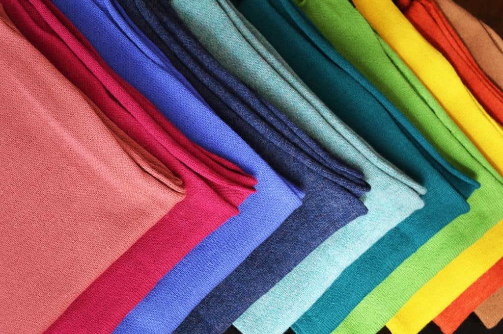 Alpaca wool scarves, folded and lined up in a rainbow of colors.